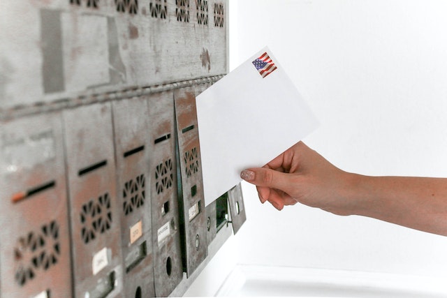 person putting mail in box