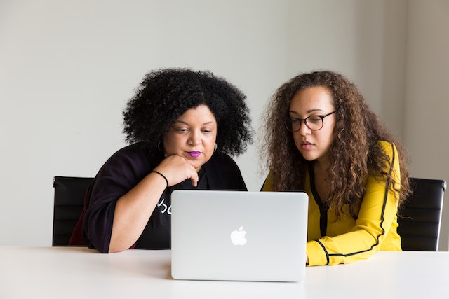 two people working together at computer